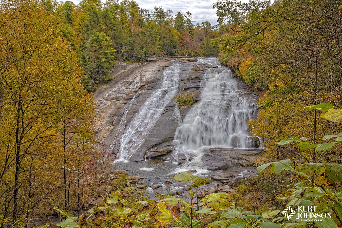 A stunning soothing waterfall image is surrounding by the golden autumn trees and foilage in seasonal shades of orange, yellow and green creating a healing focal point for healing environments.